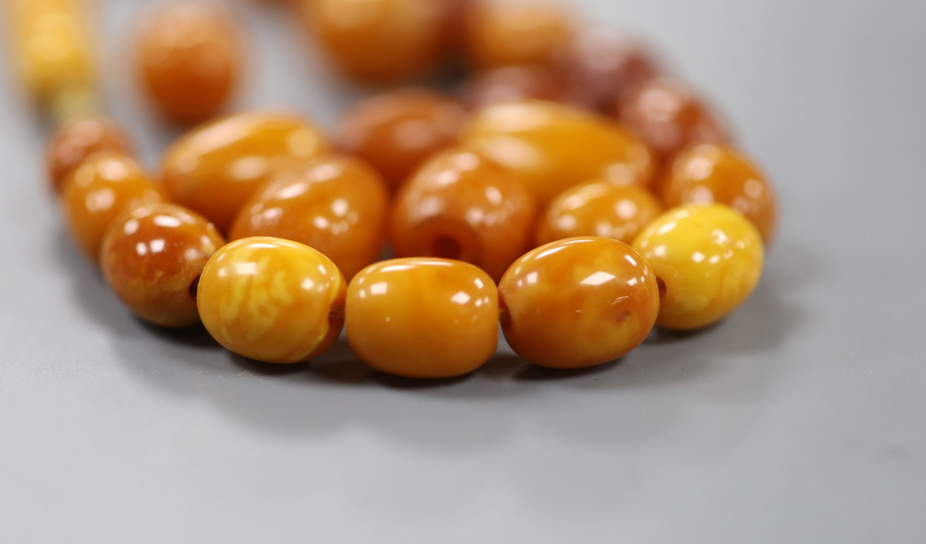 A single strand graduated oval amber bead necklace, 47cm, gross weight 33 grams.